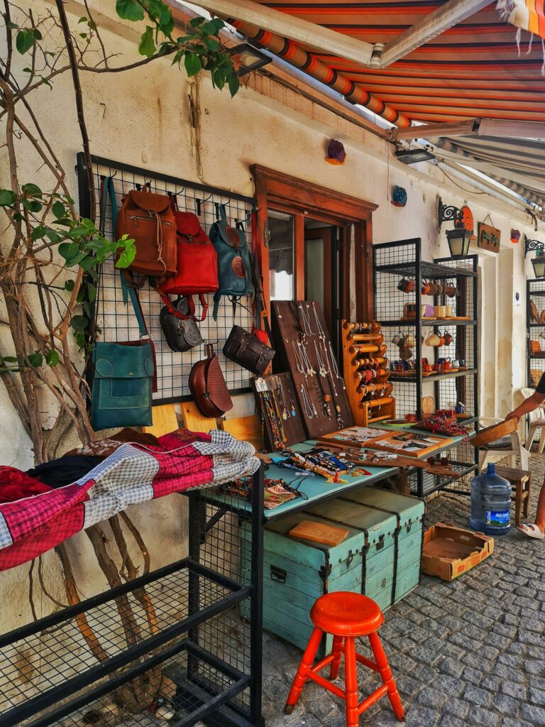Vibrant outdoor market stall showcasing handmade leather bags and crafts.